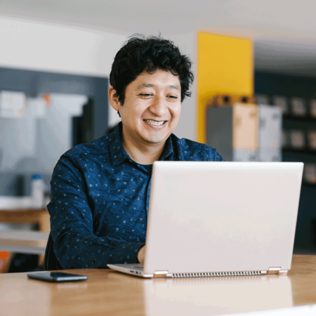 Education professional smiling at a computer