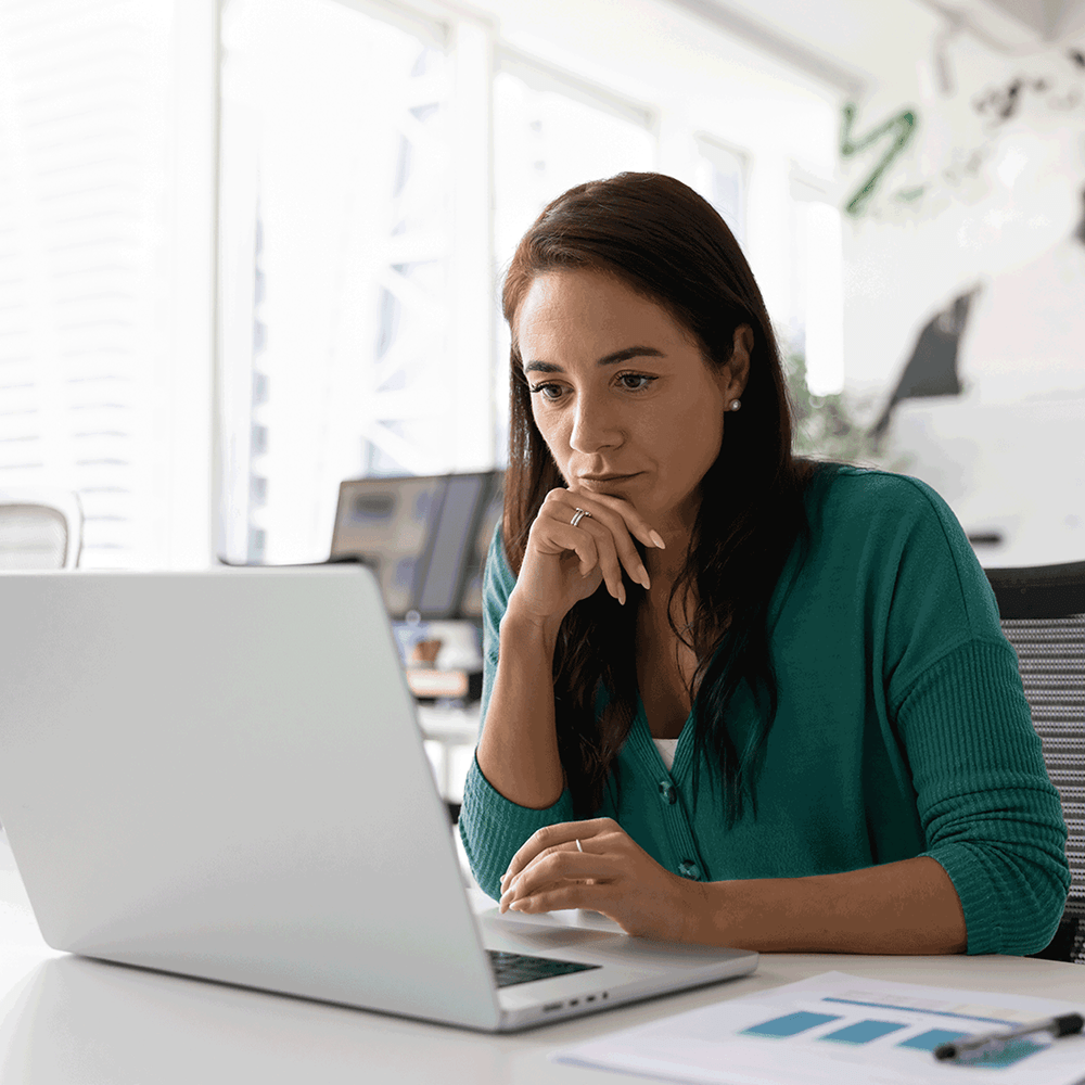 Woman at a laptop reviewing education job postings