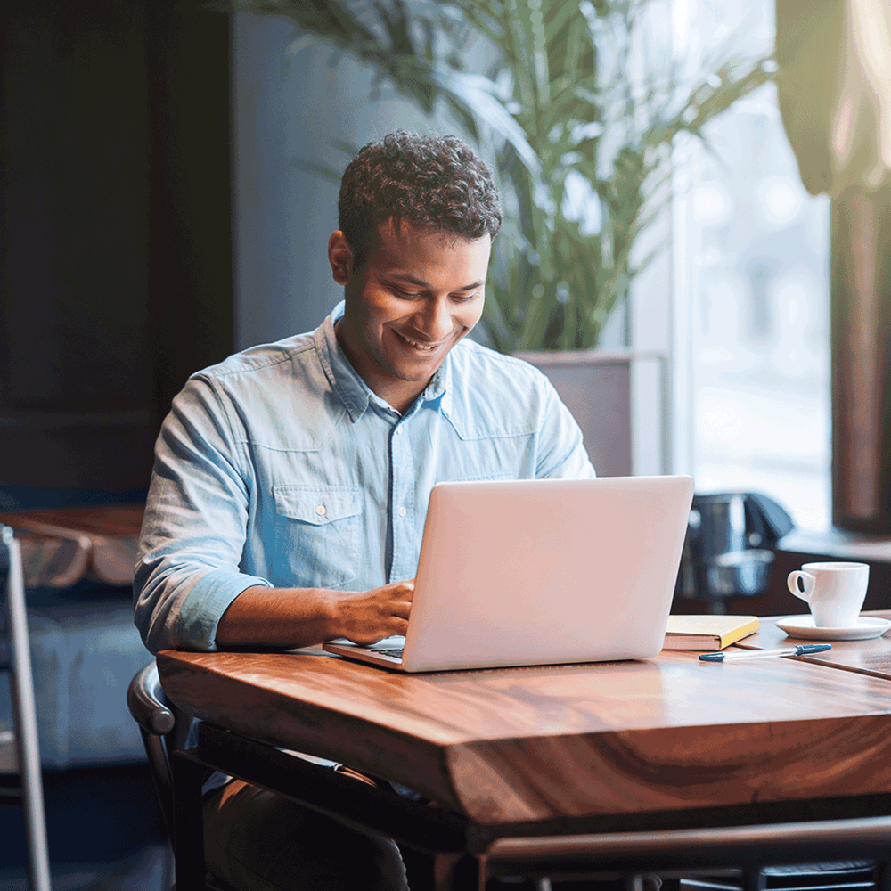 Man happily taking a course on his laptop