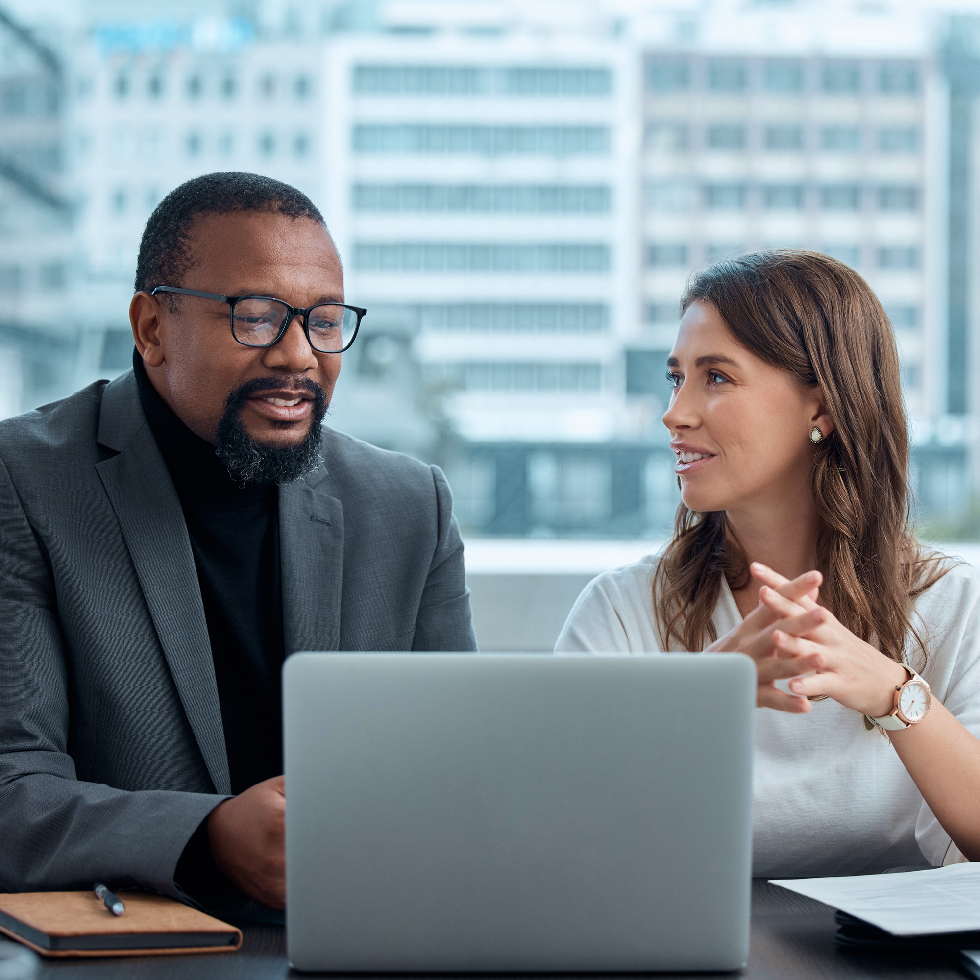 man and woman looking at computer