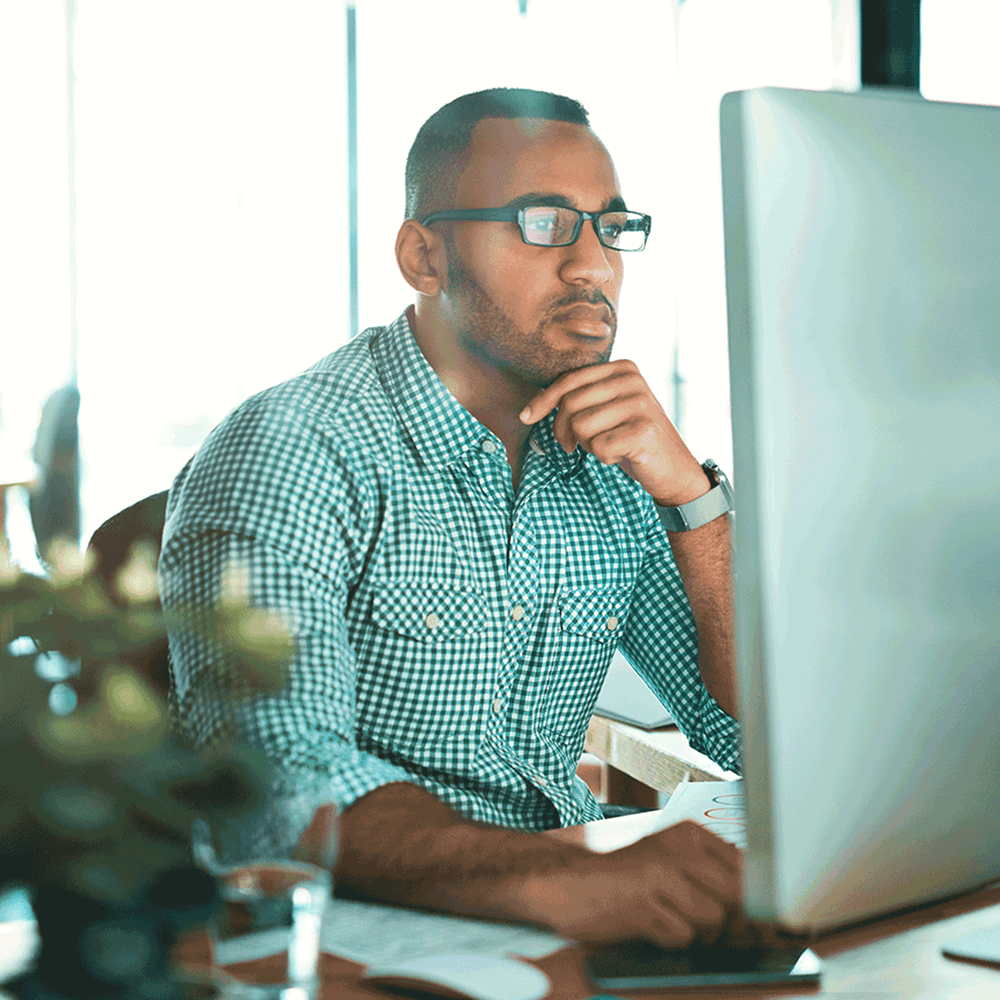 Man reviewing onboarding workflows on a desktop computer