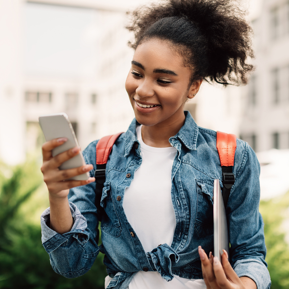 Student checking her phone on campus